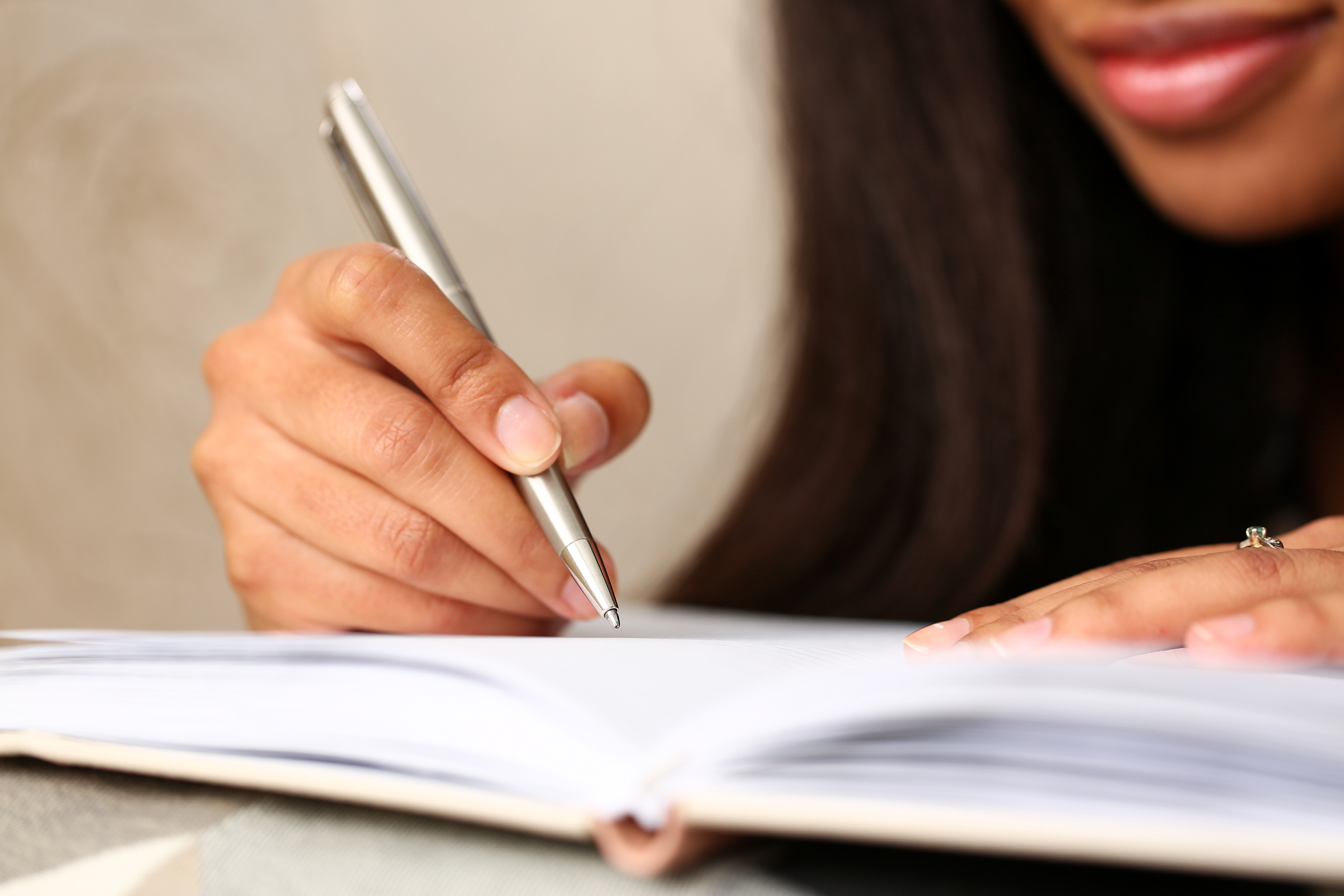 Arm of black woman write story in notebook